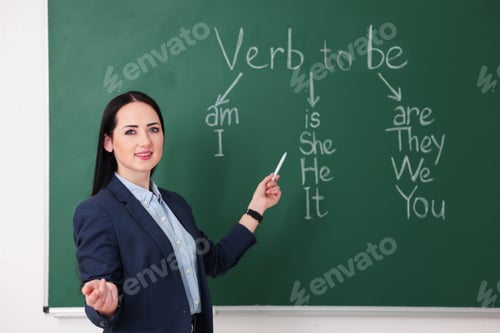 Preview: English teacher during lesson near chalkboard in classroom