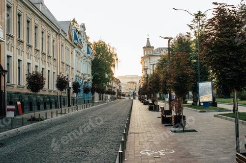 Preview: Empty city street with benches and trees at sunrise
