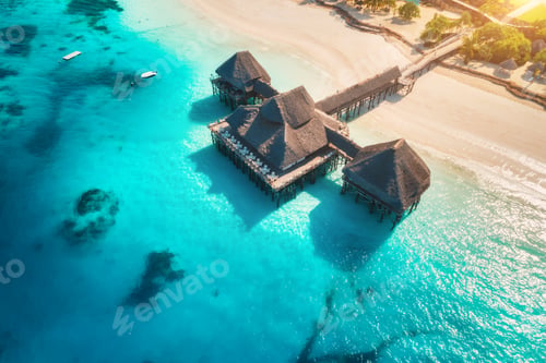 Preview: Aerial view of beautiful hotel on the water in ocean at sunset