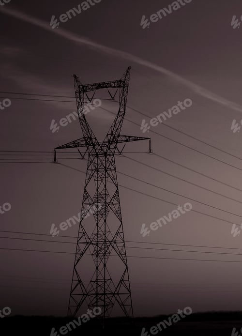 Preview: Vertical shot of a high voltage transmission tower at night