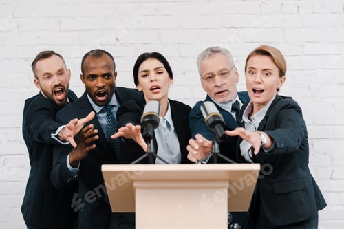 Preview: emotional multicultural politics reaching microphones near brick wall