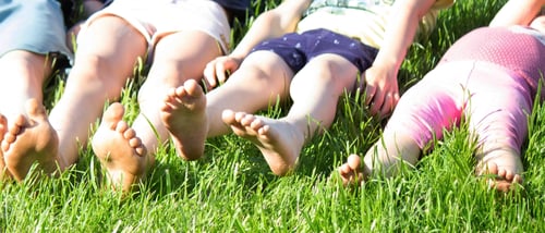 Preview: Children's legs on green grass. Selective focus.