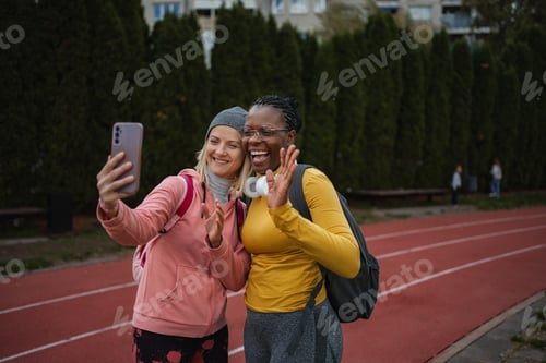 Preview: Diverse women taking selfie for video call on running track