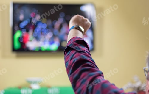 Preview: Man watching sports on tv cheering for team