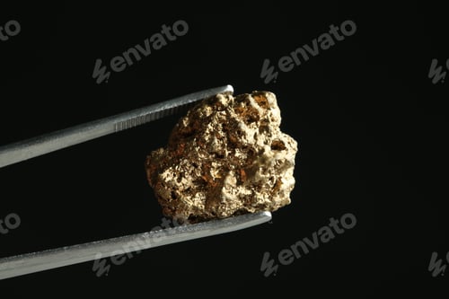 Preview: Tweezers with gold nugget against black background, closeup. Space for text