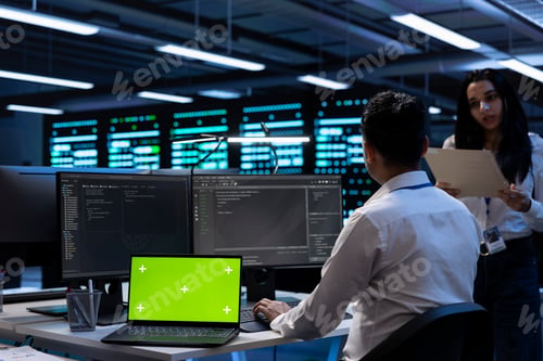 Preview: Teamworking technicians in server room using green screen laptop
