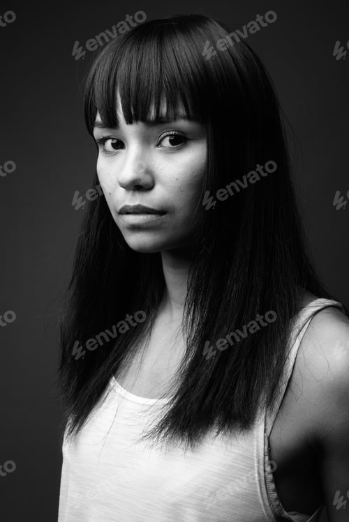 Preview: Young Asian woman against gray background in black and white