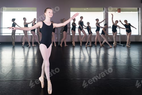 Preview: Teenage girl in ballet dance studio poses with the rest of the class behind her