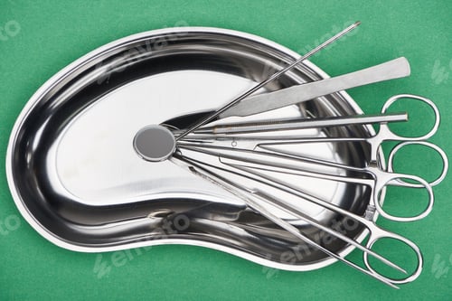 Preview: top view of set with stainless dental tools in plate isolated on green