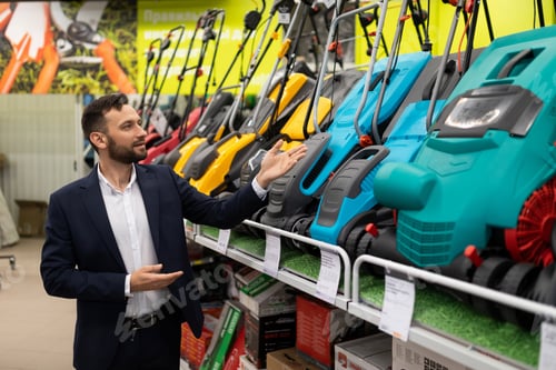 Preview: a salesperson in a gardening equipment store offers a wide range of gas and electric lawn mowers