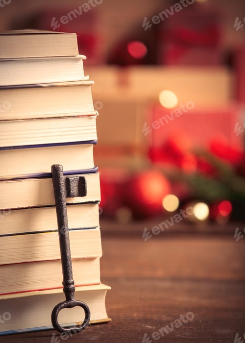 Preview: Stack of books and key with Christmas gifts on background