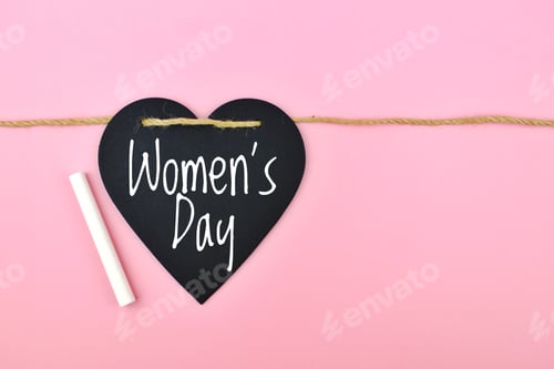 Preview: heart with the inscription Women’s Day hanging on a rope on a pink background