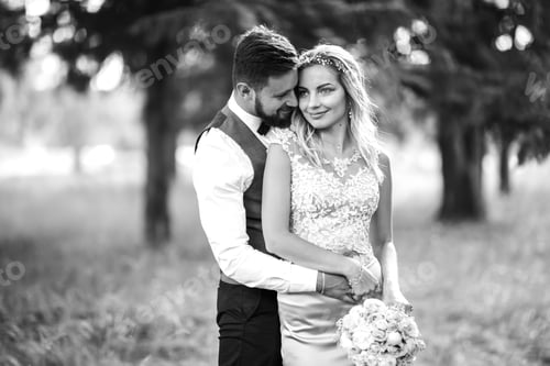 Preview: Stylish couple of happy newlyweds posing in the park on their wedding day. Perfect couple bride.