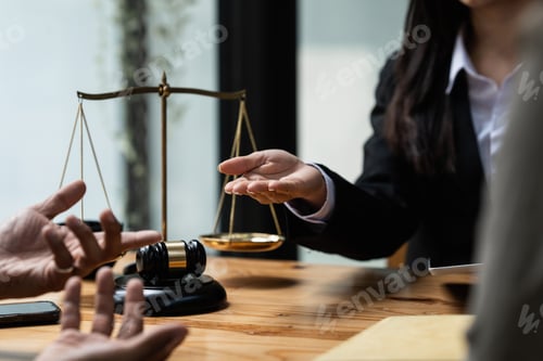 Preview: Business people and lawyers discussing contract papers with brass scale on wooden desk in office