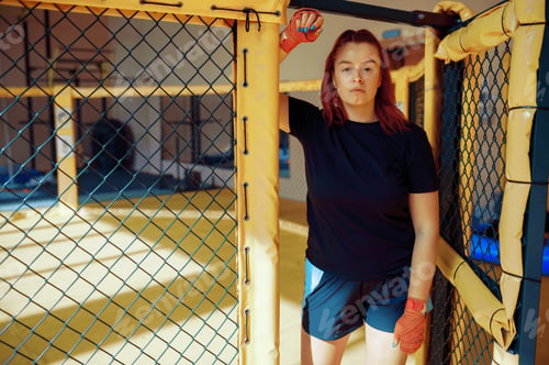 Preview: Female MMA fighter in bandages poses in gym