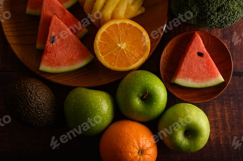 Preview: Watermelon, pineapple, oranges, cut into pieces with avocado, Broccoli and apples on wood table.