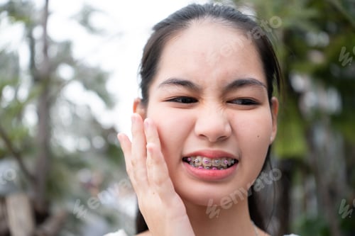 Preview: Portrait of a young asian woman with braces on her teeth
