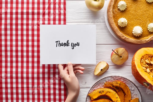 Preview: cropped view of woman holding thank you card on wooden white table