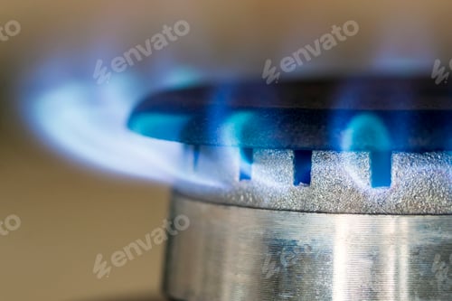 Preview: Natural gas blue flames burns on the kitchen stove hob, close up photo with shallow DOF