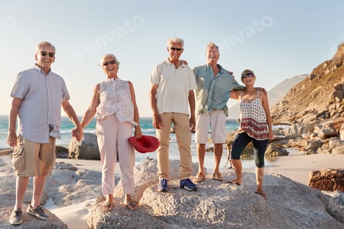 Preview: Portrait Of Senior Friends Standing On Rocks By Sea On Summer Group Vacation