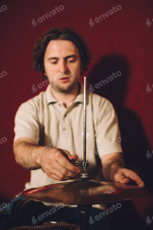 Preview: Drummer setting up a cymbal on a stand in a professional recording studio