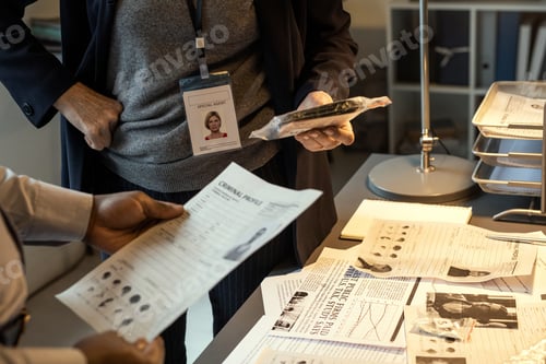 Preview: Hands of African American FBI agent looking through one of criminal profiles