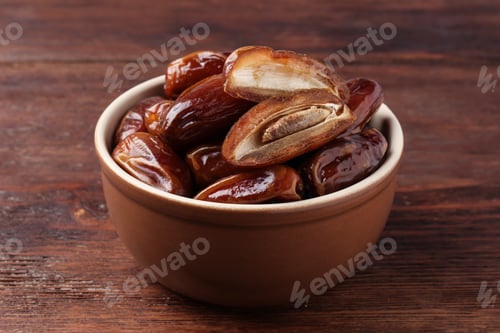 Preview: Sweet dried dates in bowl on wooden table, closeup