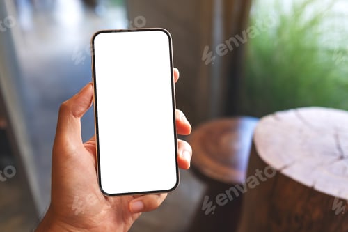 Preview: Mockup image of a man holding mobile phone with blank white screen in cafe