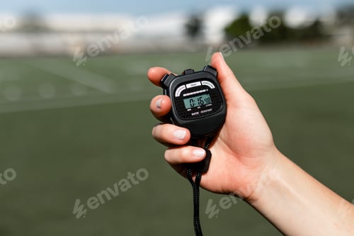 Preview: Hand Holds Stopwatch on Green Field During Daytime