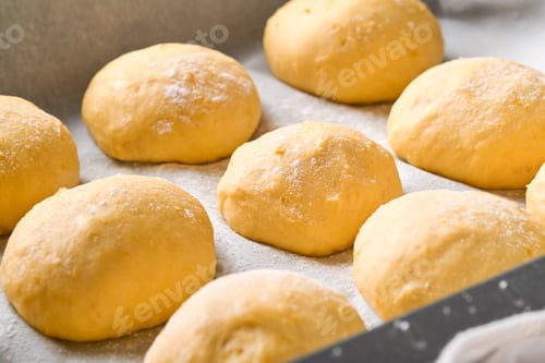 Preview: Raw yeast dough balls background in frying pan before baking. Concept home baking bread, buns or cin