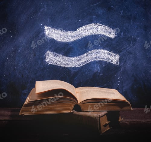 Preview: Zodiac sign Aquarius on chalkboard above old astrology books.
