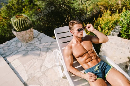 Preview: Muscular Man Posing in Swim Trunks Outdoors
