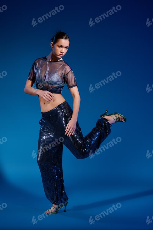Preview: Stylish young woman showcases modern fashion in a vibrant studio setting