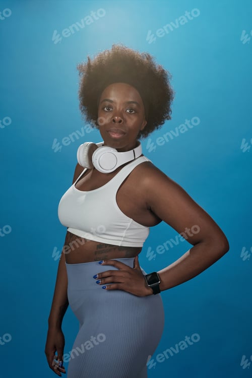 Preview: Young serious African woman in activewear standing in front of camera