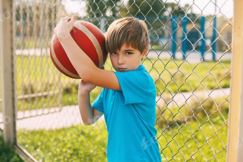 Preview: Portrait of a beautiful boy in a sports uniform with a basketball in his hands. Sports, education,