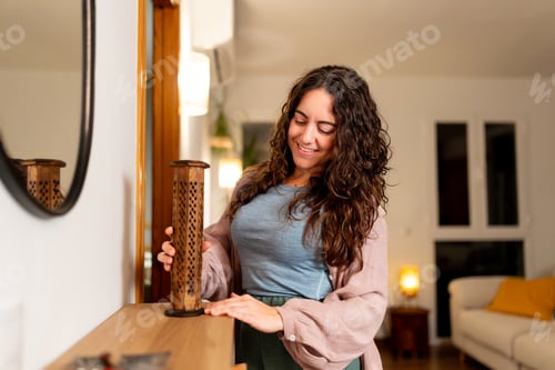 Preview: Woman enjoying relaxing evening adjusting home aroma diffuser