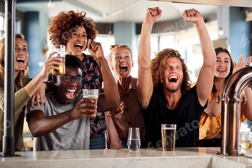 Preview: Group Of Male And Female Friends Celebrating Whilst Watching Game On Screen In Sports Bar