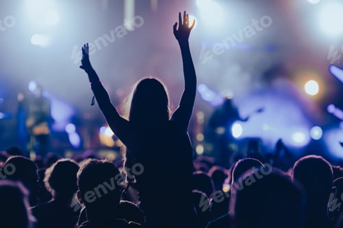 Preview: Silhouette of a woman with raised hands on a concert