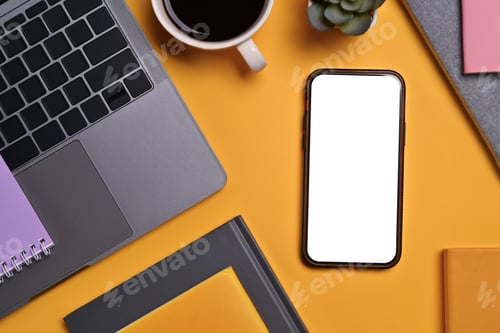 Preview: Flat lay, top view smartphone with blank screen, laptop, cup of coffee and book on yellow background