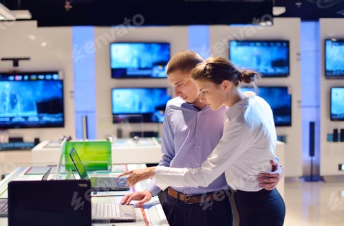 Preview: People In Consumer Electronics Retail Store Looking At Latest Laptop, Television And Photo Camera