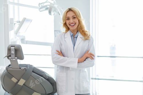 Preview: Young blonde woman dentist posing at dental cabinet