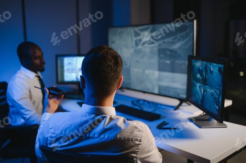 Preview: Two male security guards looking at computer screen while one of them explaining detail of video