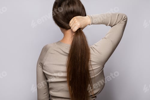 Preview: Woman Holding Her Long Brown Hair in Studio