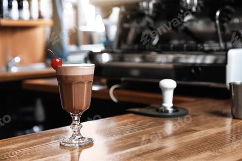 Preview: Glass of coffee drink with cherry on bar counter. Space for text