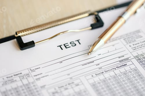 Preview: Blank educational test for students lies on table in classroom with pen
