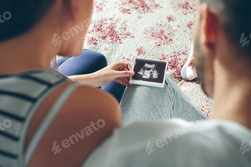 Preview: Couple looking at ultrasound of their baby