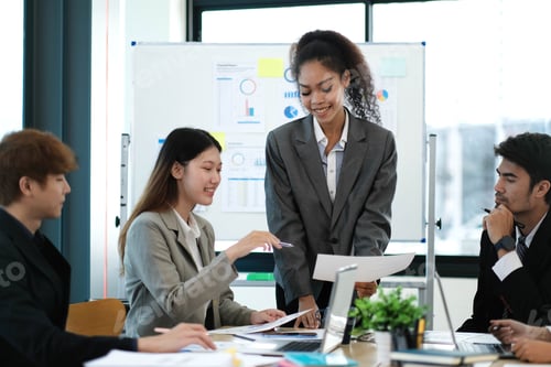 Preview: Asian business woman leader in a meeting with her multi-ethnic colleagues at the office presenting s
