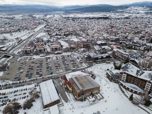 Preview: Winter landscape of a busy resort town Bansko with snow-covered mountains and crowded parking lot