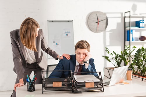 Businesswoman Consoling Depressed Businessman in Modern Office