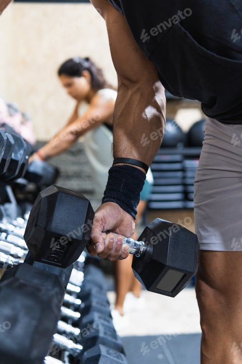 Preview: Anonymous sportsman near dumbbells weight set